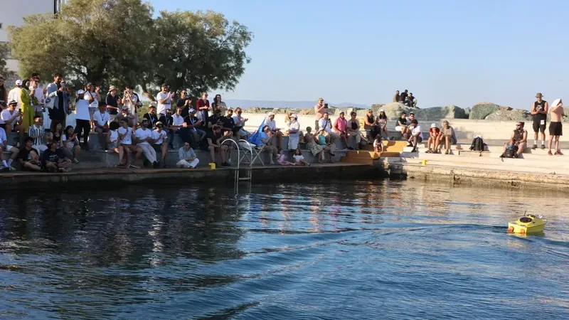 Spectators at the waterfront watching an autonomous vessel race